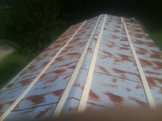 Rusted metal roof panels with new wood purlins before replacement — Storm Damage Roof Repair in Suttons Bay by Roofing Brothers